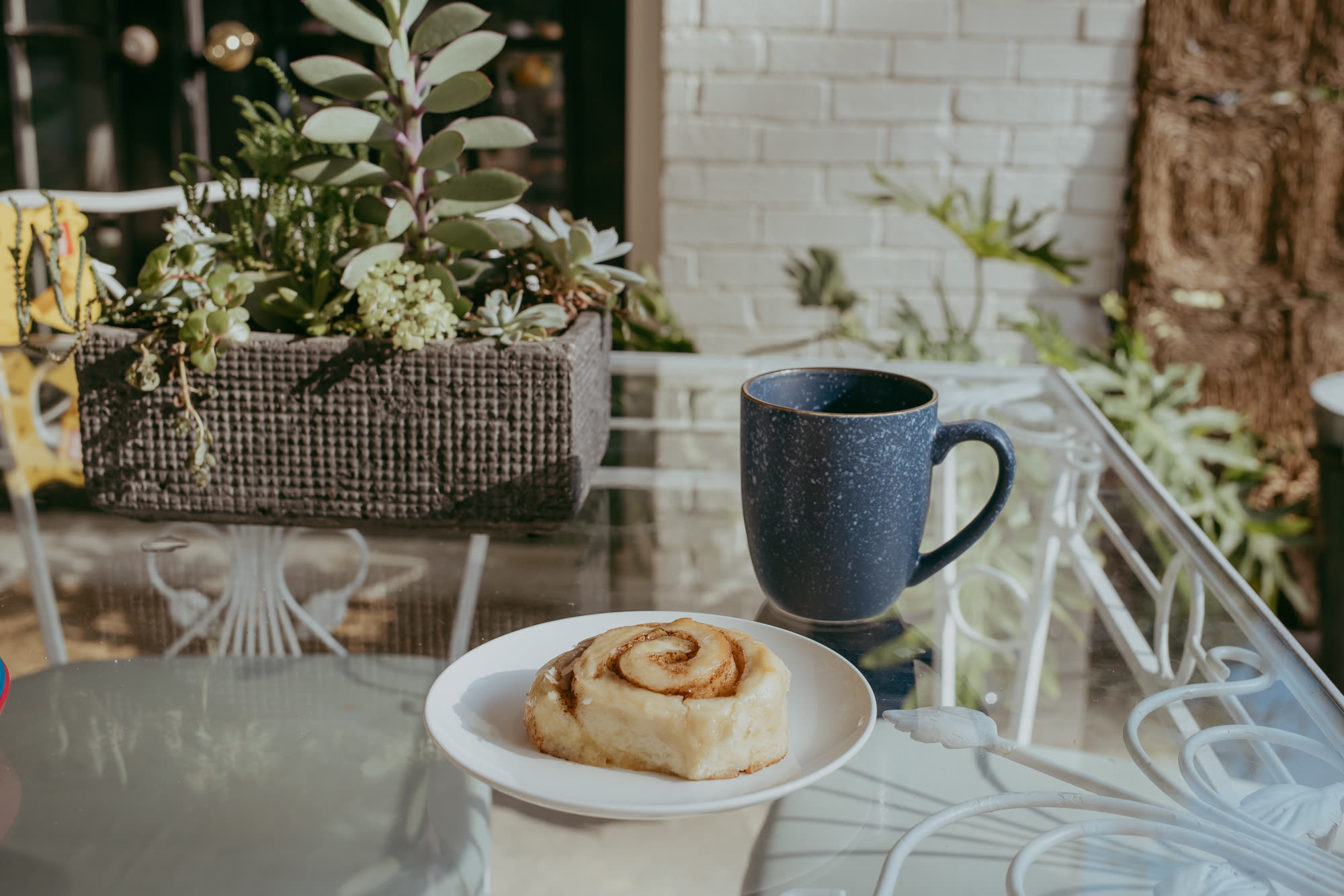 A roll and coffee on a sunny patio